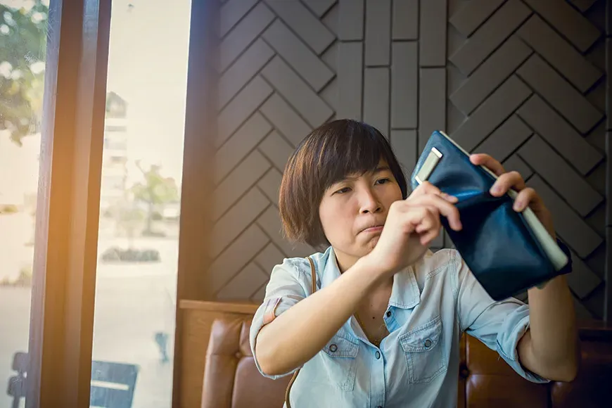 Asian woman with no money in coffee shop she looking empty pocket